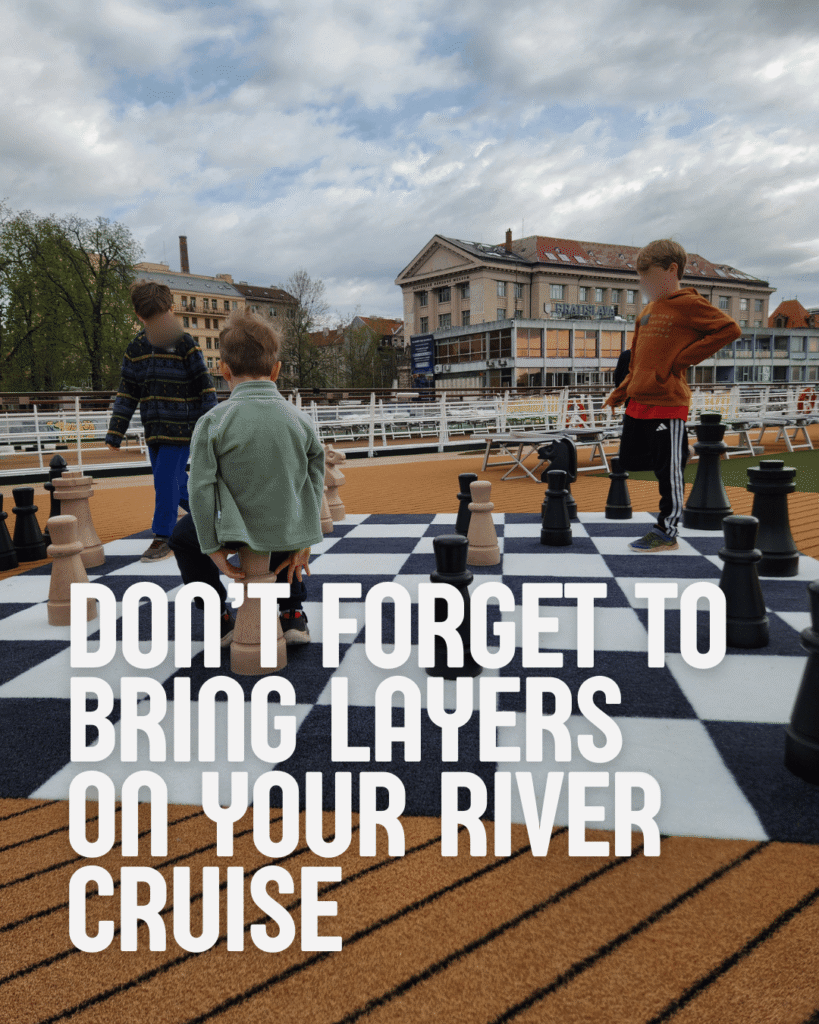 Text: Don't forget to bring layers on your Arosa river cruise. Picture: Three boys playing chess on top of the Arosa Donna ship.