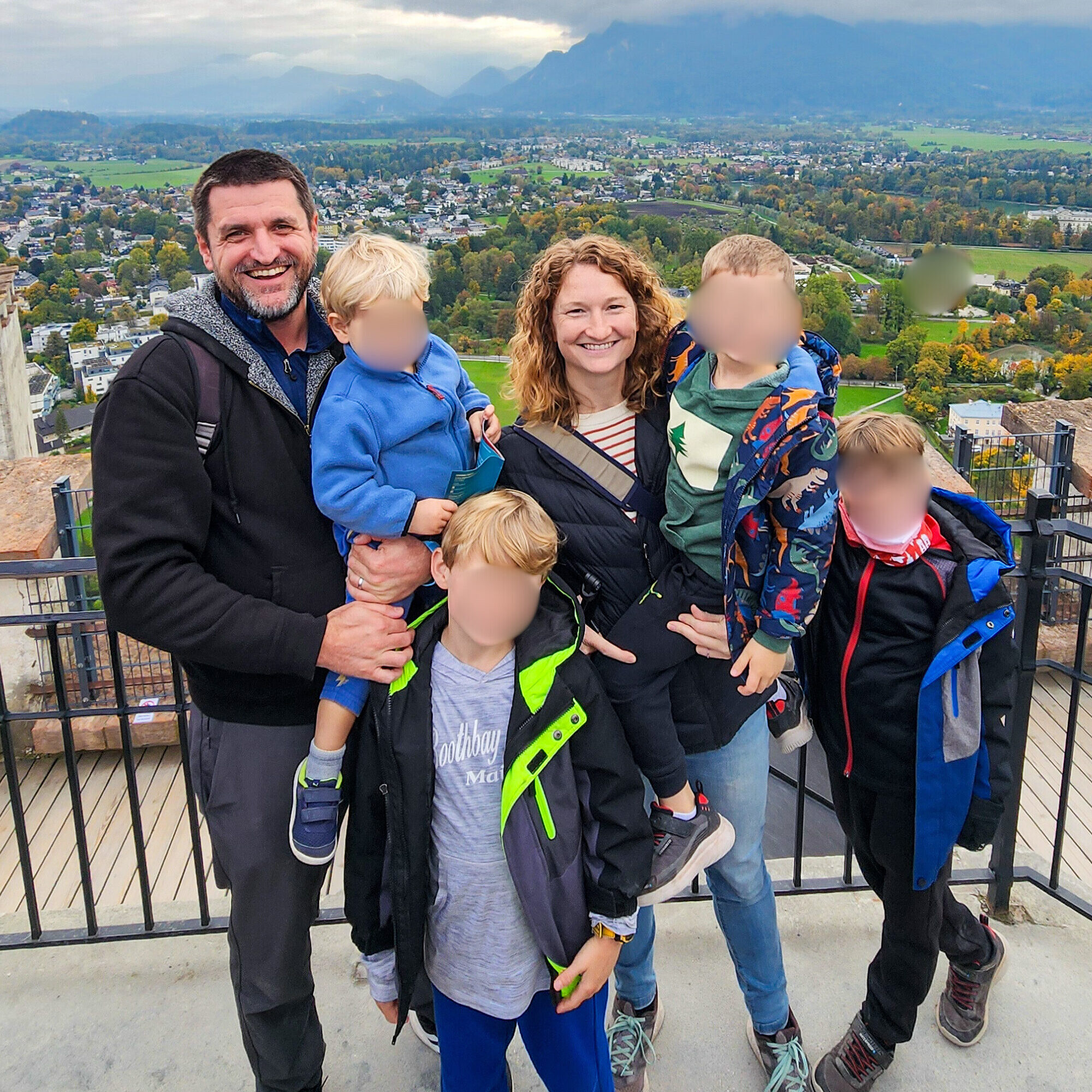 if you give a kid a passport family with mom, dad and four young boys standing in front on scenic green landscape