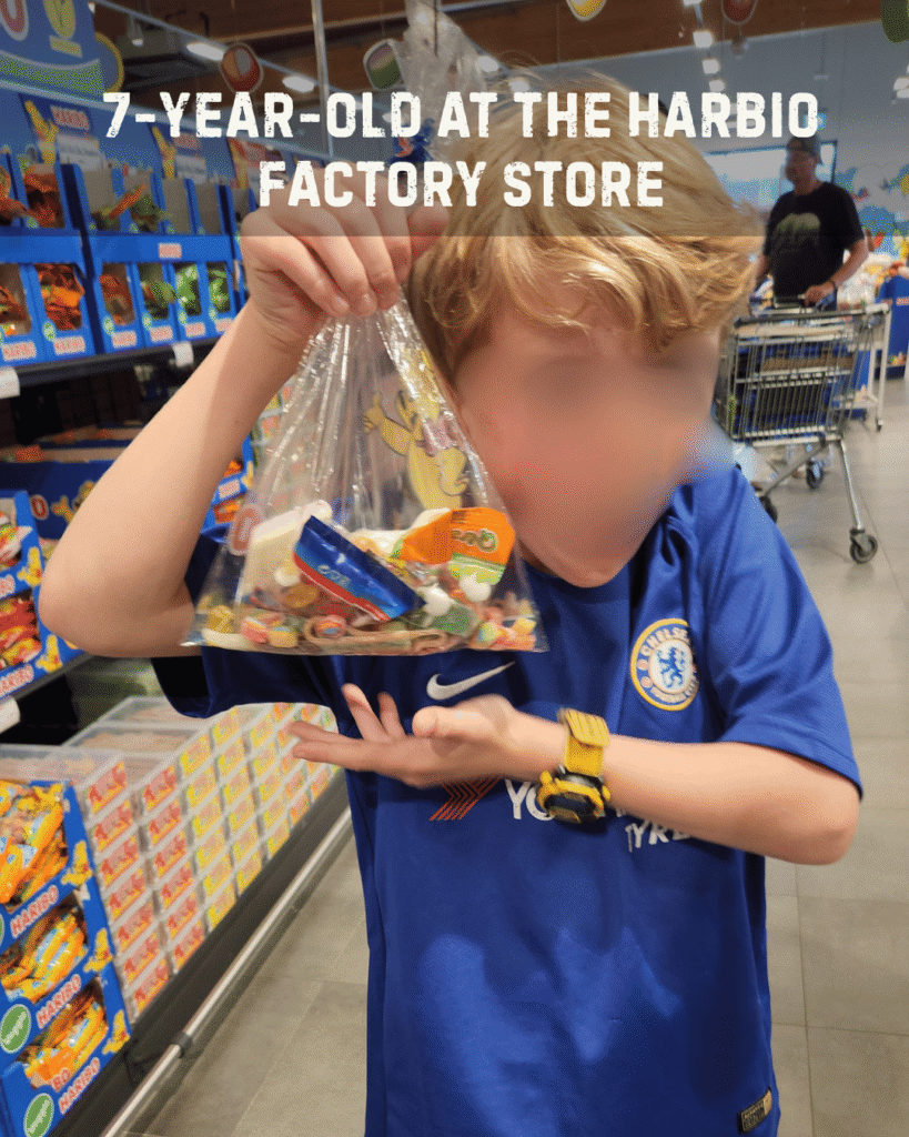 7-year-old gift guide includes candy. Boy in Haribo factory store with a fill-your-own bag of Haribo candy.