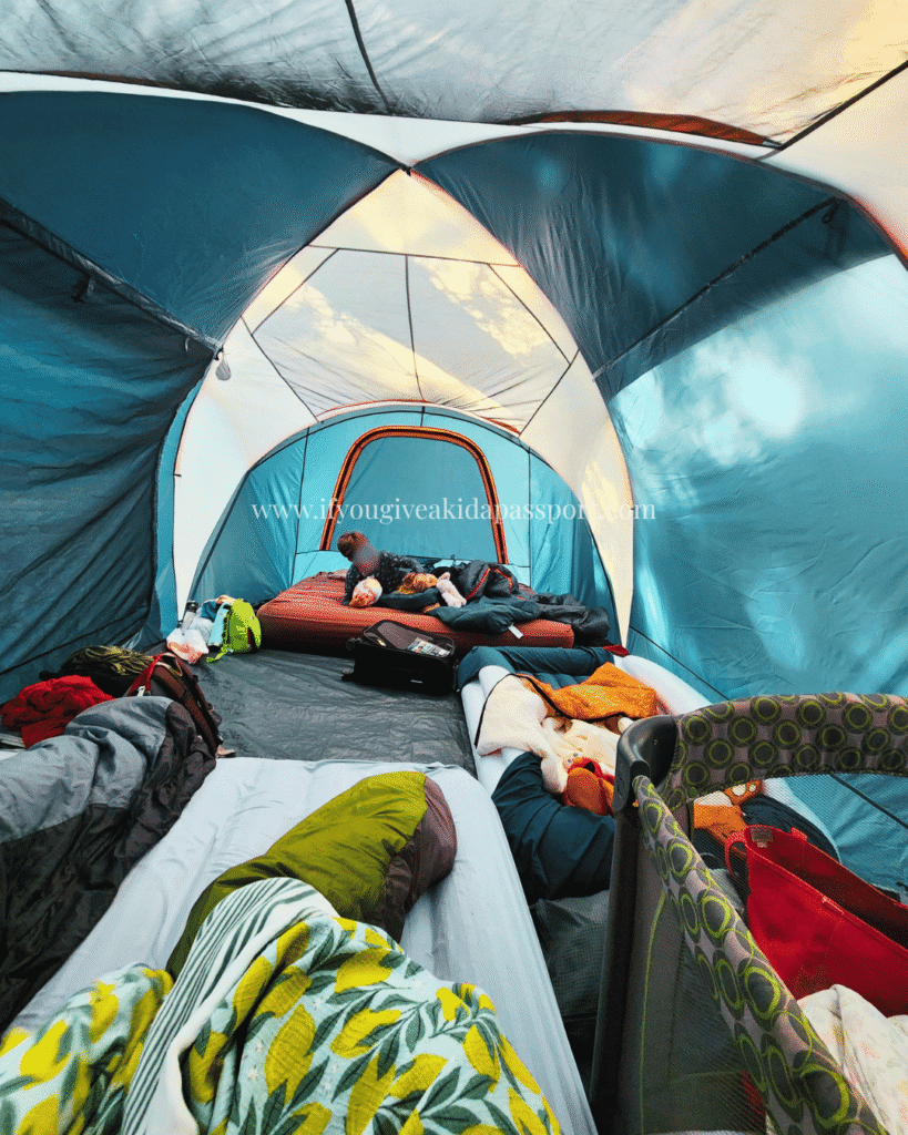 View inside the tent with a 10 person tent (featuring 2 queen airmattresses, one twin mattress and a pack n play. Fish Creek campground in Glacier National Park