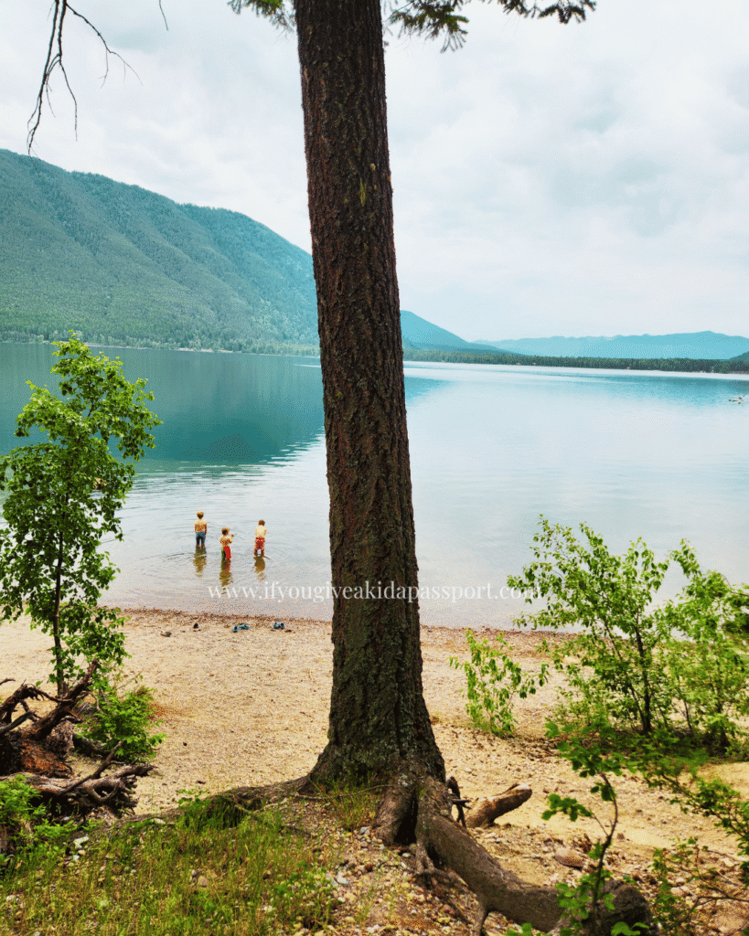 Lake McDonald, walkable from Fish Creek campground in Glacier National Park. Three boys entering the chilly water.